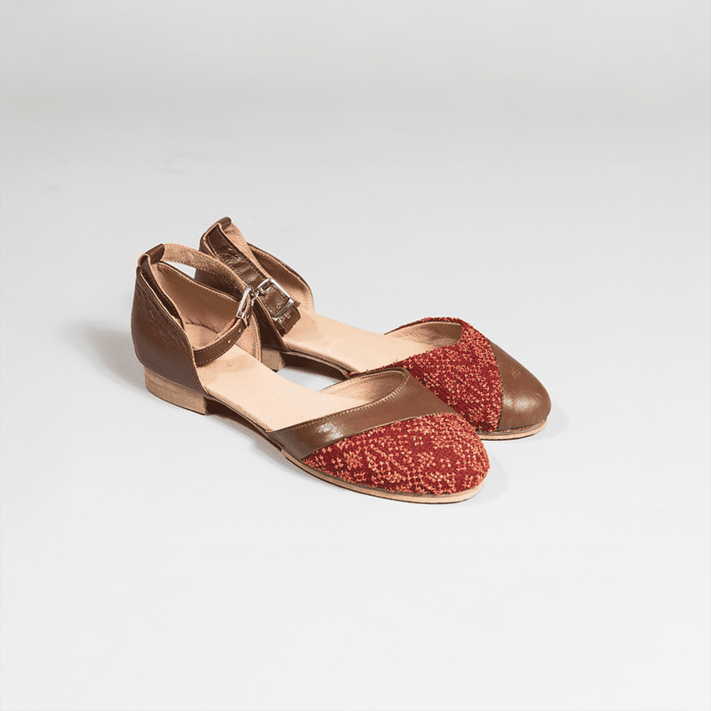 The Carnation Dress  shoe is designed with metallic gold thread, making it an elegant addition to any collection. 