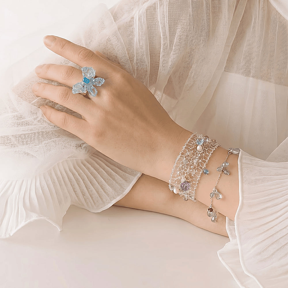 Discover the Celestia Multi-Gemstone & Pearl Silver Mesh Bracelet at The Luxe Maison, featuring luminous pearls, blue topaz, amethyst, and tourmaline woven into an elegant silver mesh design for a celestial touch.