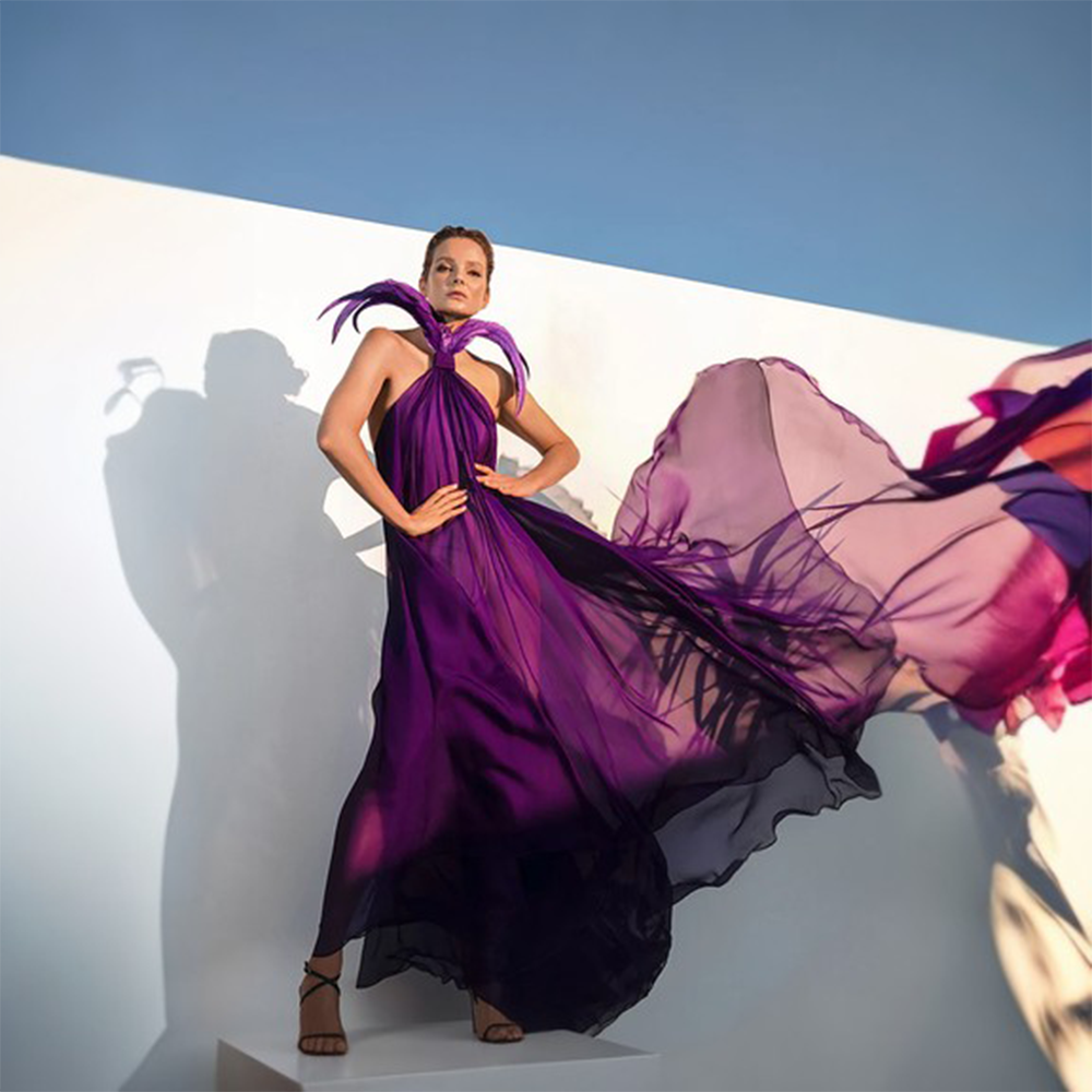 A purple chiffon halter neck dress finished with coq tail plumes.