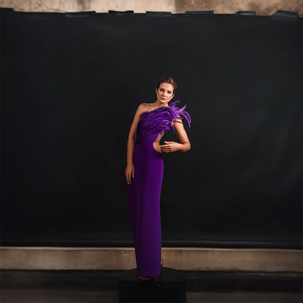 A purple chiffon halter dress featuring ruffled feather sleeves.
