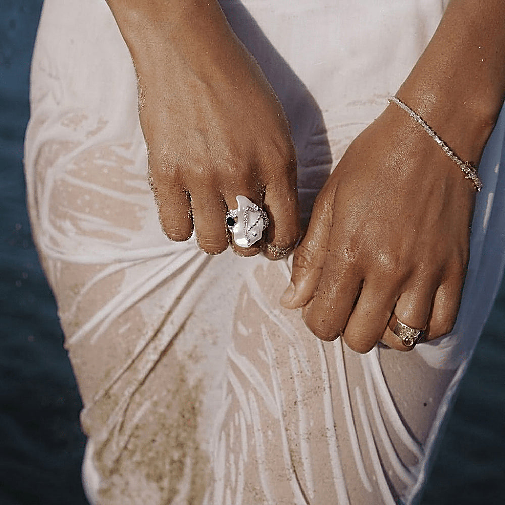 Discover the Circe Mother of Pearl Ring at The Luxe Maison, featuring a luminous mother-of-pearl centerpiece set in a sculptural silver-tone design. Inspired by moonlit waters and oceanic mystique, this elegant statement ring captures the iridescent beauty of the sea with a modern, enchanting finish.