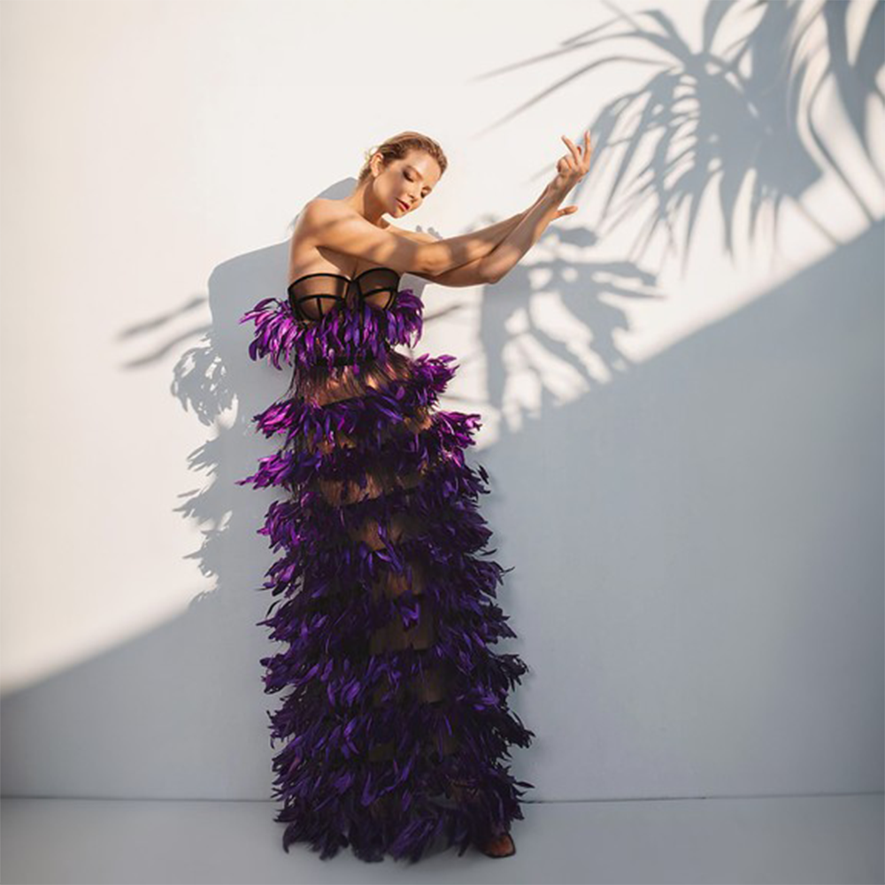 A corseted dress in black tulle and ruffled coq plumes.