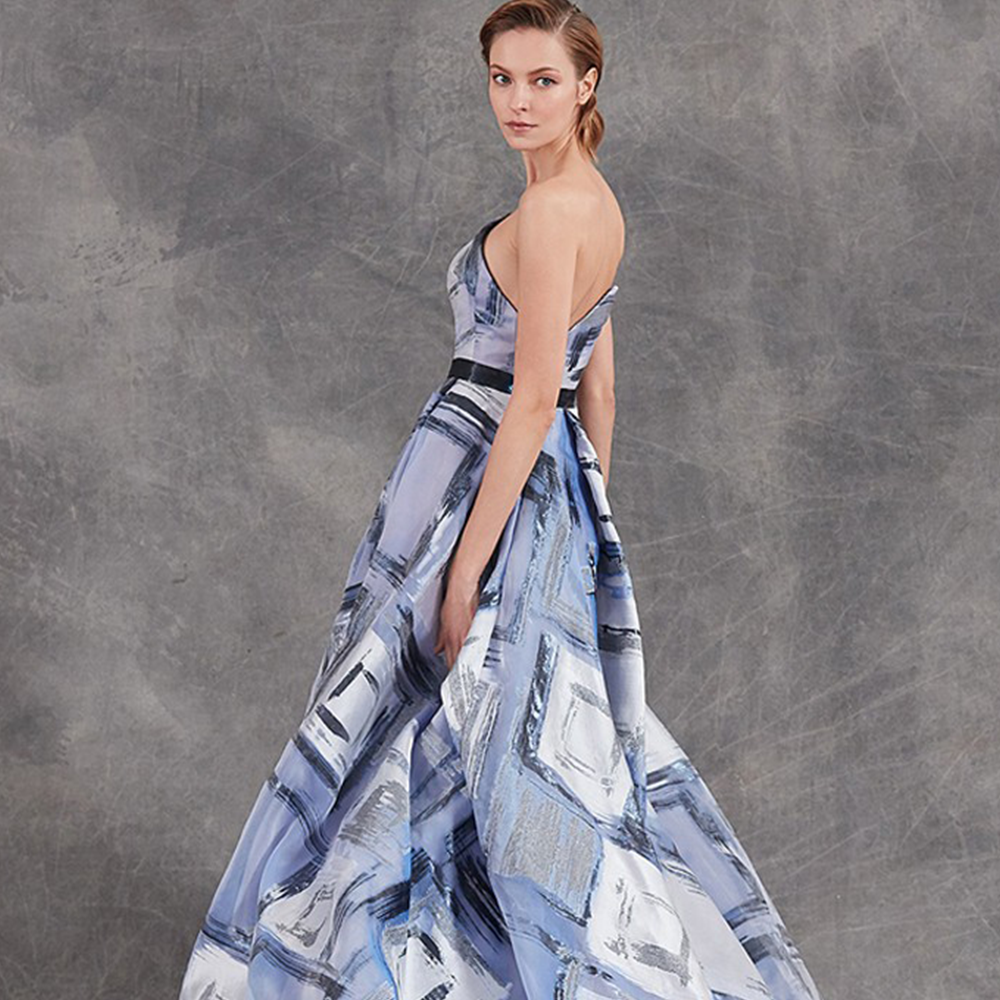 Asymmetric strapless ballgown in organza with glossy belt.