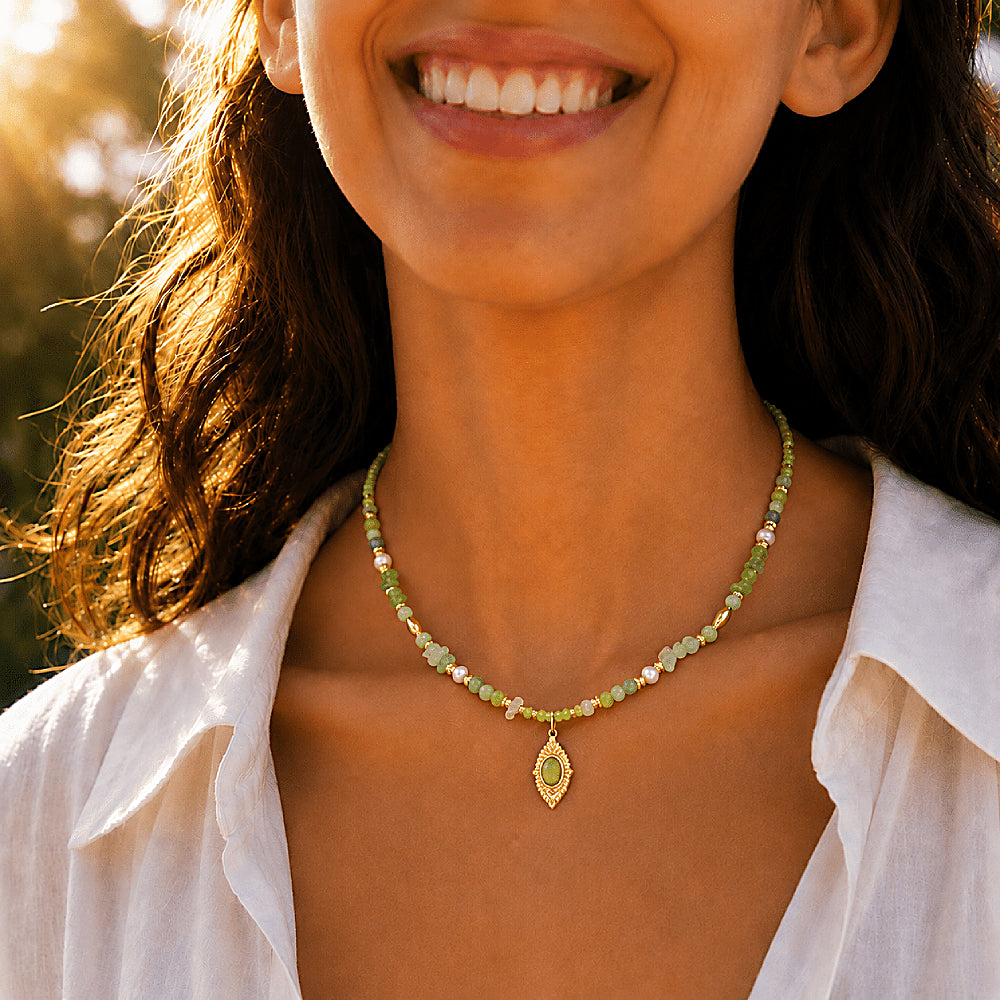 Discover the Daphne Green Gemstone Necklace at The Luxe Maison, featuring freshwater pearls, prehnite, peridot, green aventurine, Xiuyan jade, and Alxa agate in harmonious forest-green hues. Finished with a radiant golden talisman pendant, this handcrafted necklace celebrates nature, renewal, and timeless elegance.