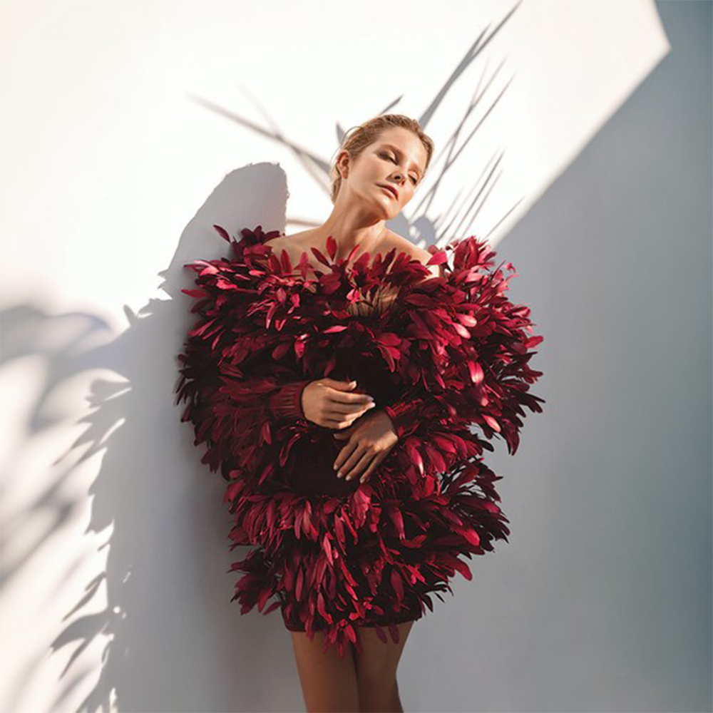 A deep saturated burgundy dress in ruffled feathers.