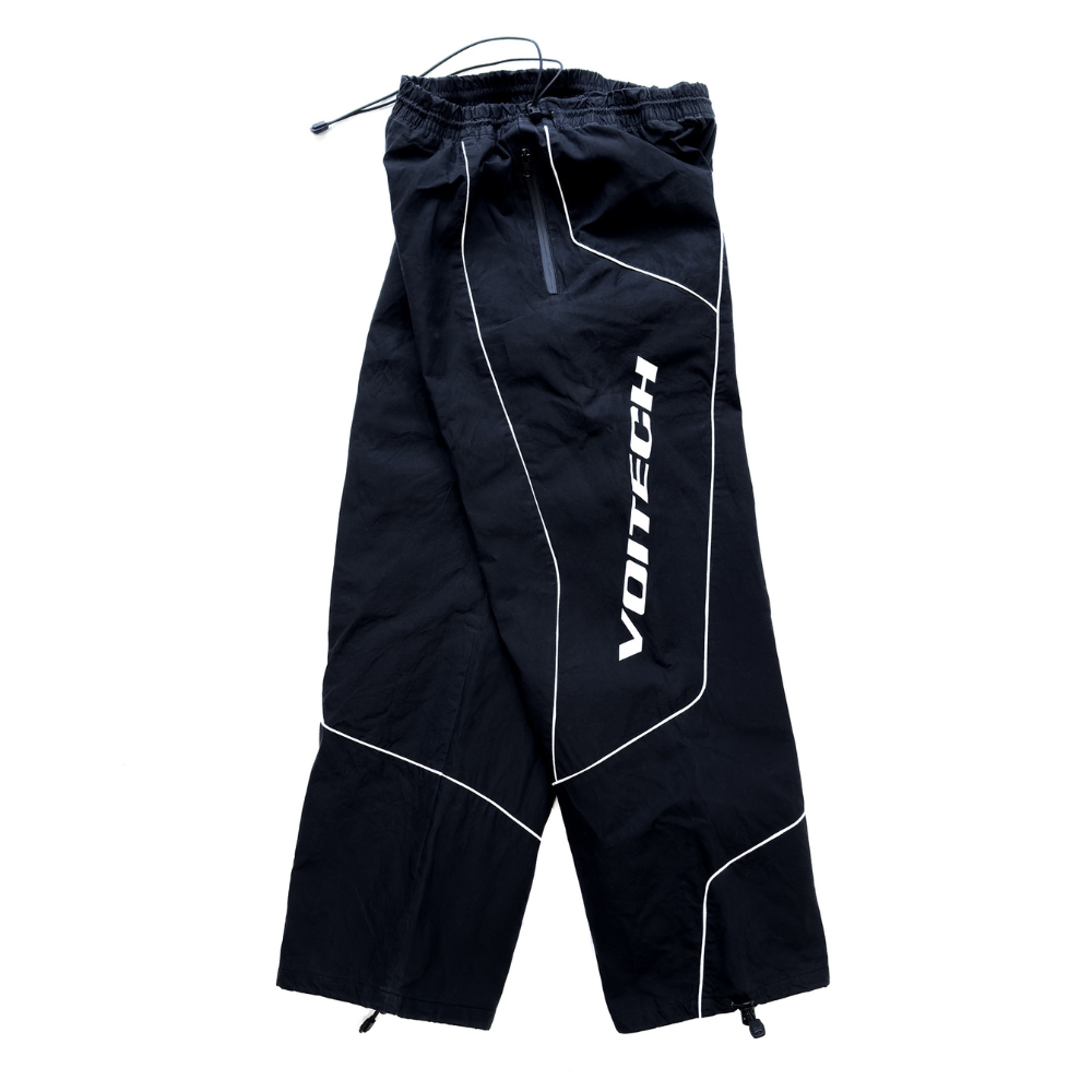 Shop online from our exclusive website and discover the Delta Track Pants by Voitech®, crafted from lightweight technical nylon with an engineered silhouette for futuristic streetwear.