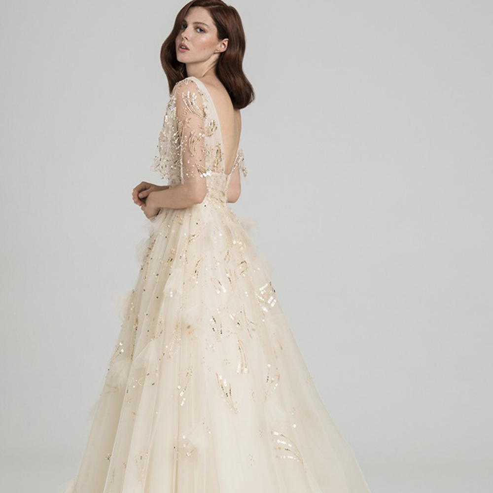 Ball gown in hand embroidered tulle with v neckline and sleeves.