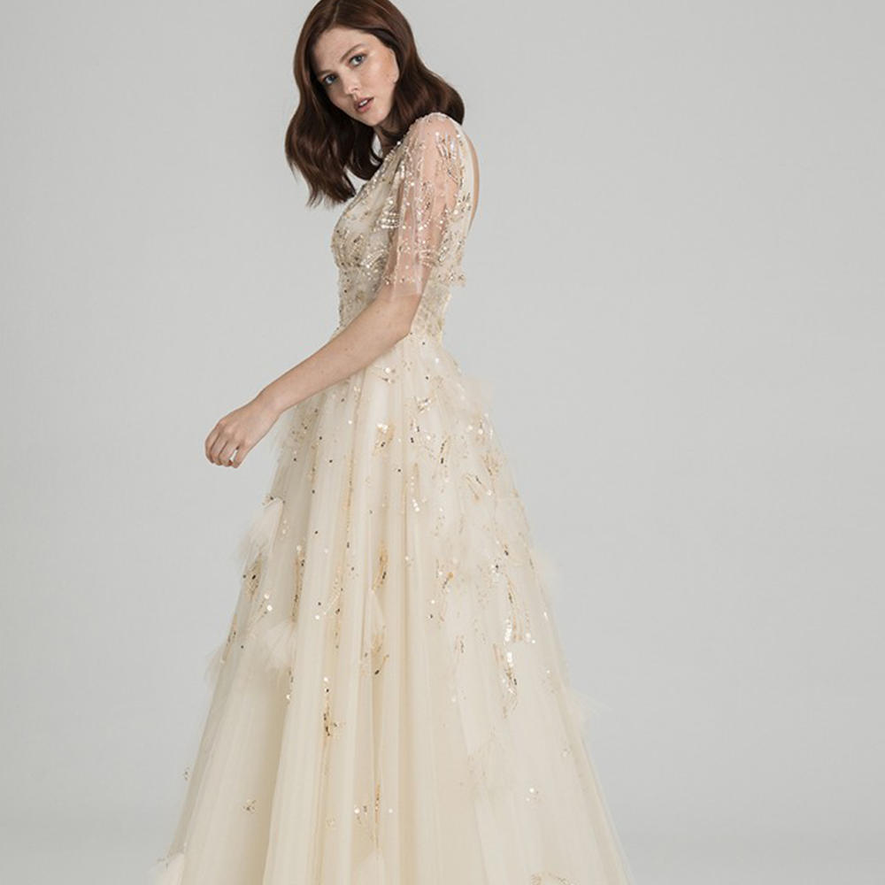 Ball gown in hand embroidered tulle with v neckline and sleeves.