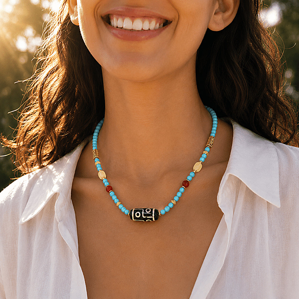 Discover the Dolma Turquoise & Dzi Bead Necklace at The Luxe Maison, featuring agate Dzi beads, turquoise, carnelian, and amber in a timeless design.