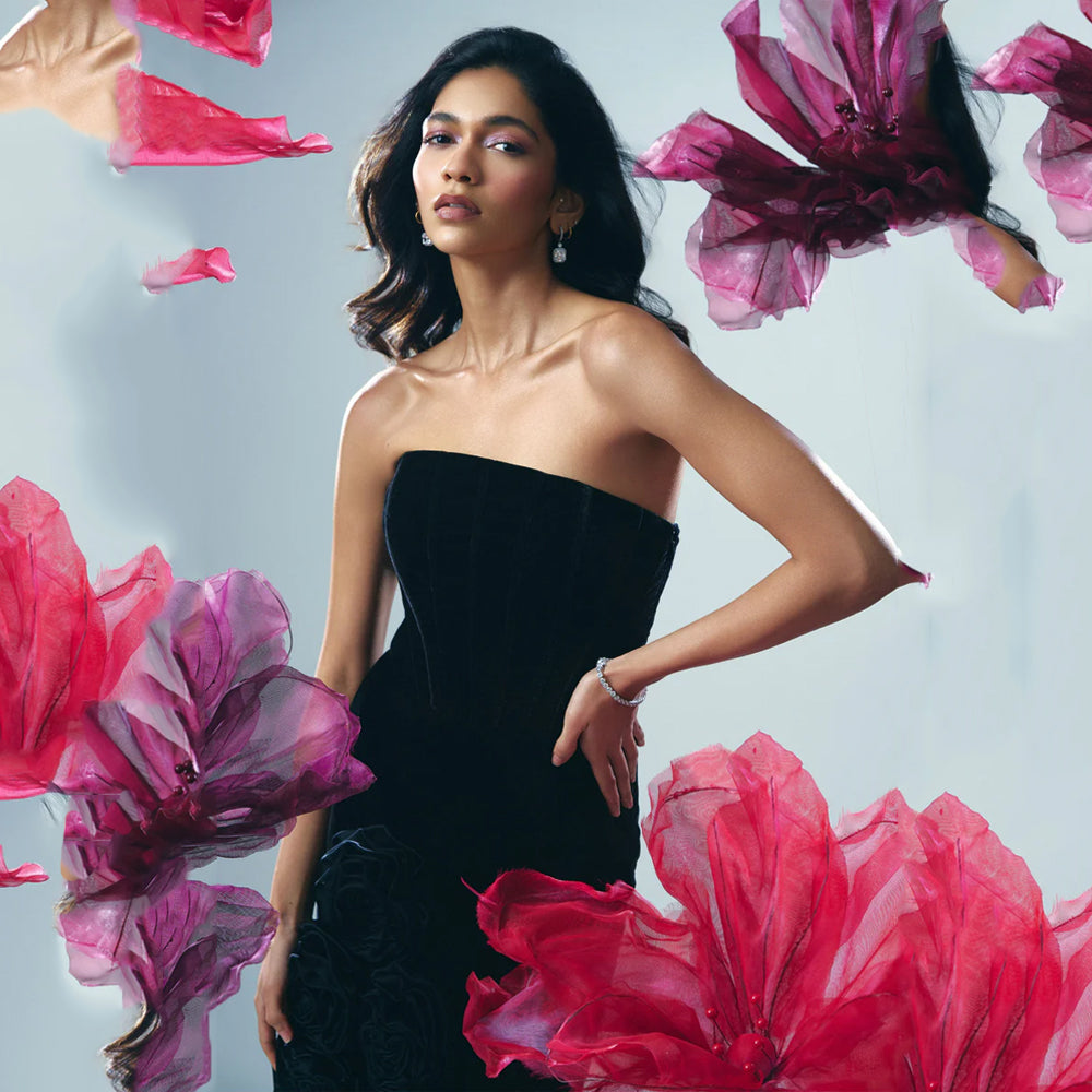 Black velvet corset gown with slit and rose detail, perfect for evening events. Shop online from our curated edit of premium fashion.