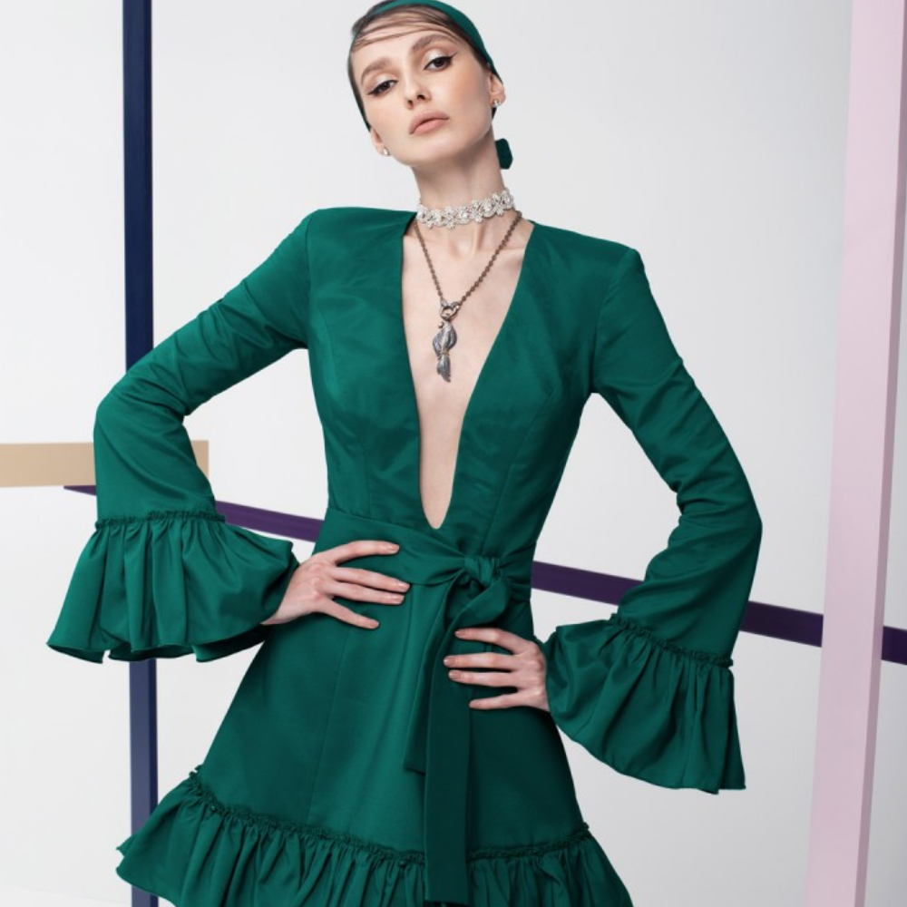 This emerald green full sleeves, short dress is perfect party wear. It has ruffles on the sleeves and the skirt.