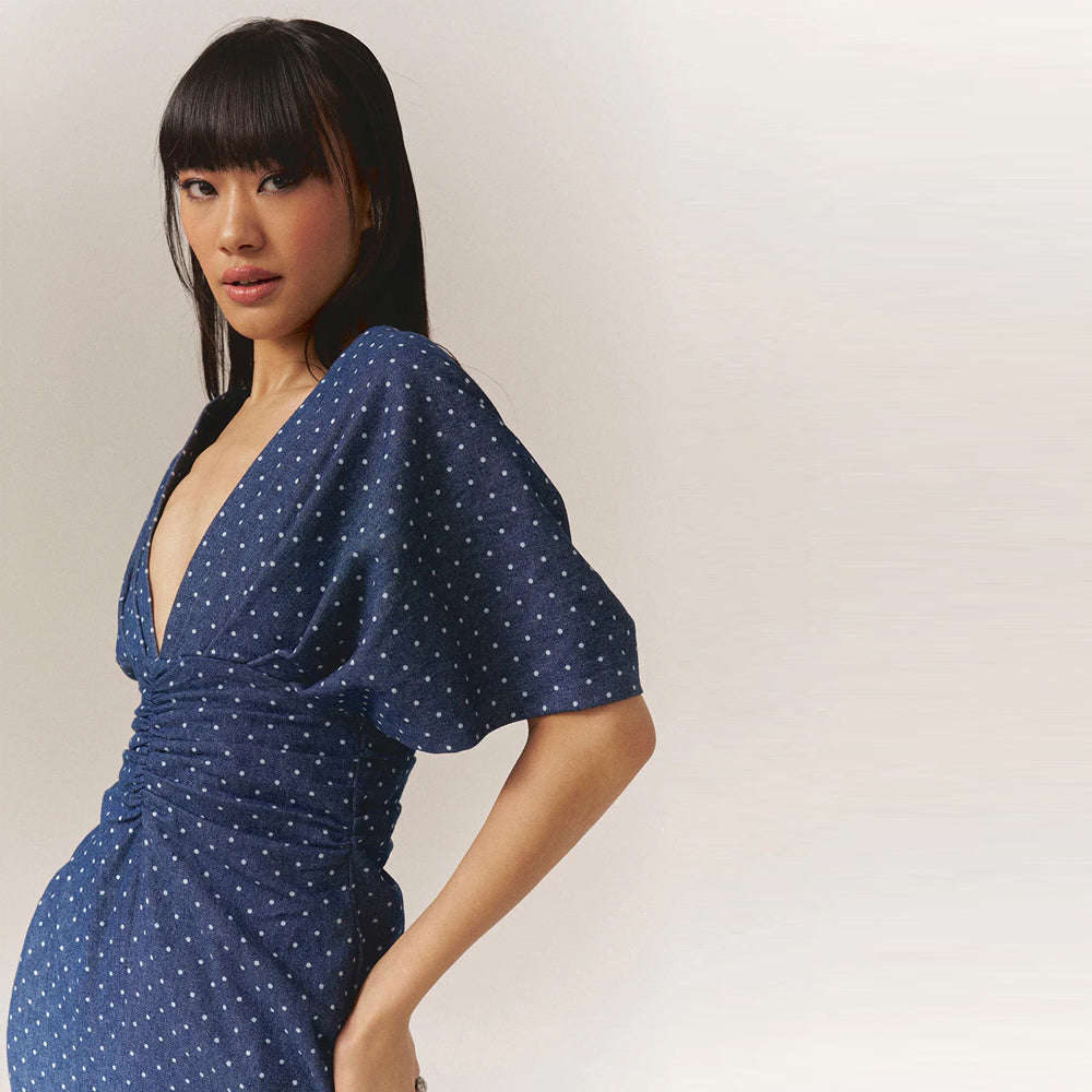 Polka dot denim dress with twisted front & slit hem waist-accentuating, perfect for brunch, birthdays, baby showers & garden parties.