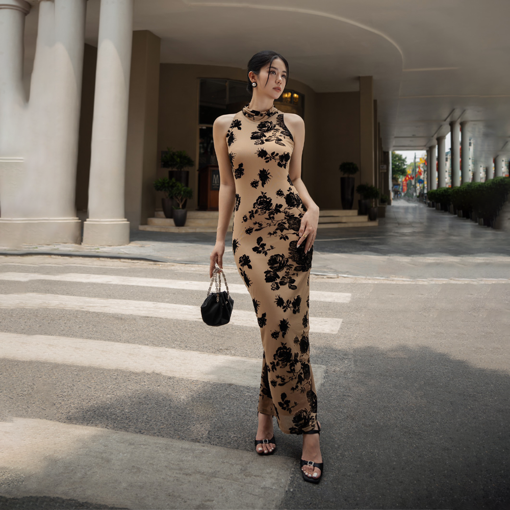 Striking in its simplicity, this nude brown dress with rose print dress is cut with a halterneck and a floor-grazing hemline.