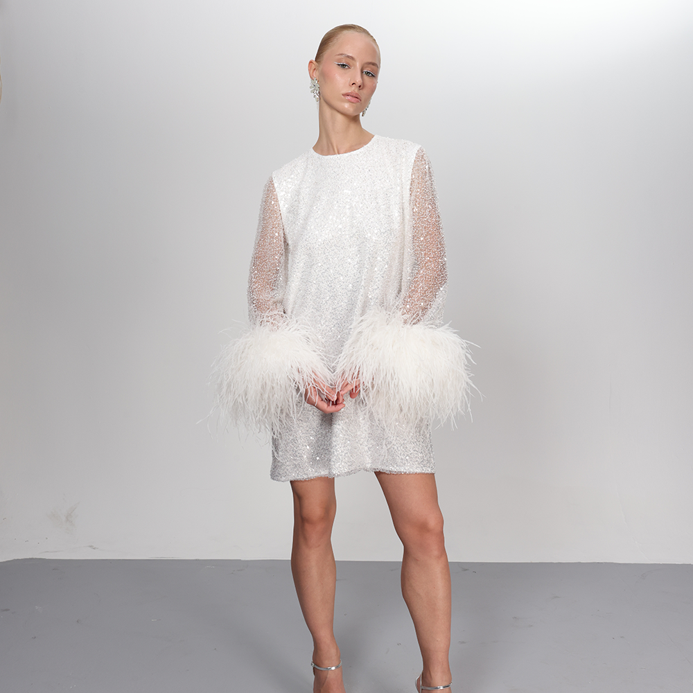 This exquisite dress, meticulously hand-sewn and adorned with splendid feathers cascading around the sleeves.