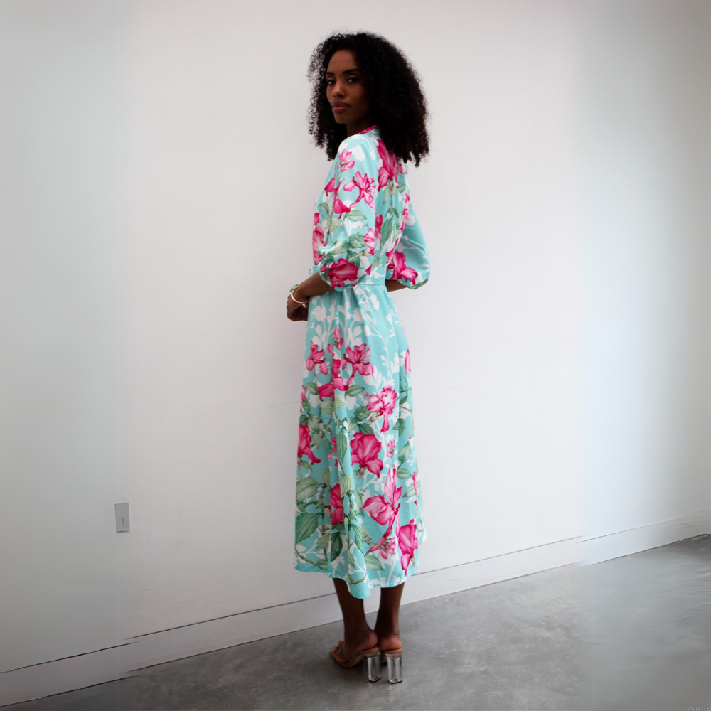 This sophisticated shirt midi dress features a bold pink floral pattern with a turquoise and white background