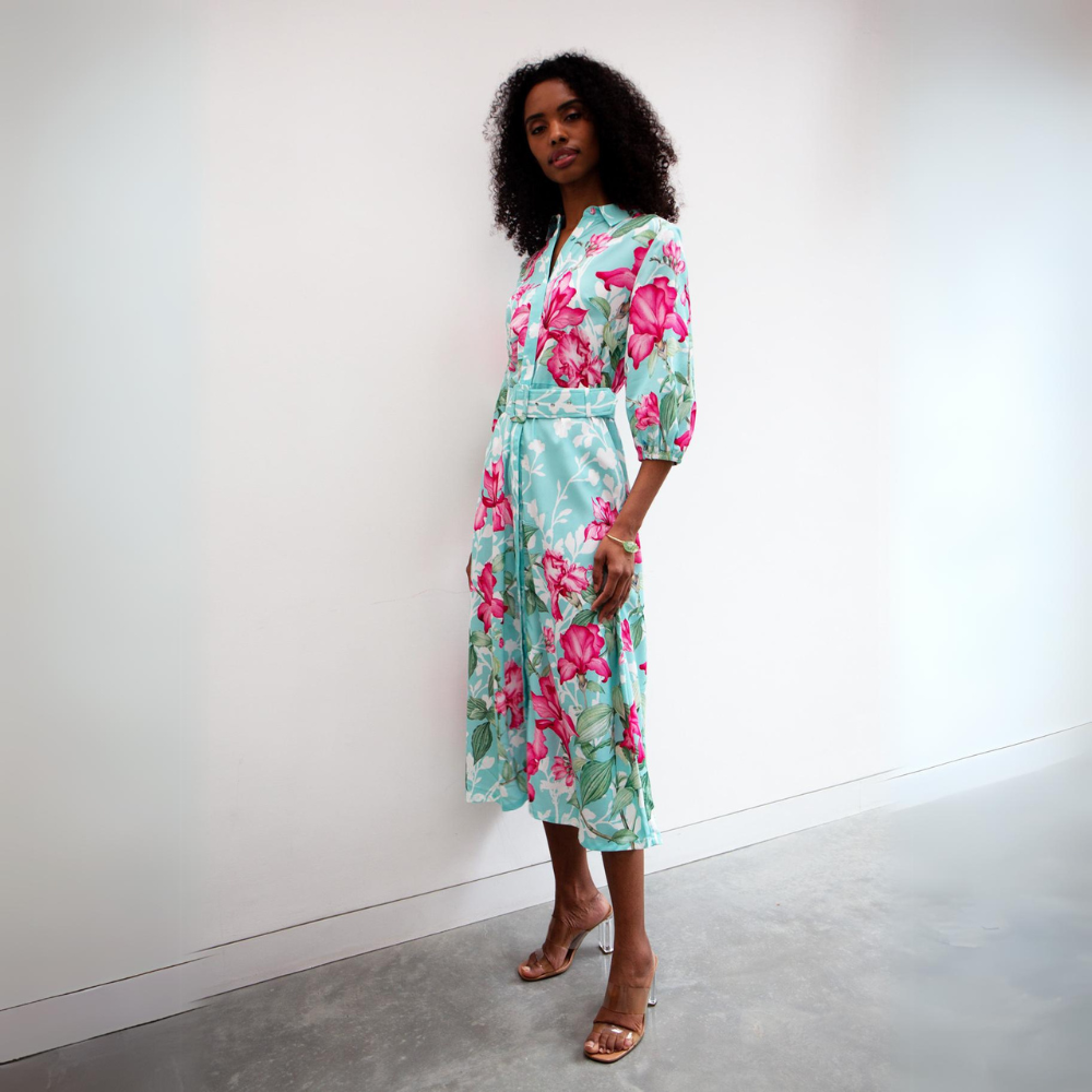 This sophisticated shirt midi dress features a bold pink floral pattern with a turquoise and white background