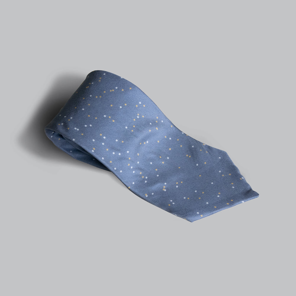 A stonewashed blue tie dotted with white and glamour gold, making it a perfect accessory with lighter suits or even denims.