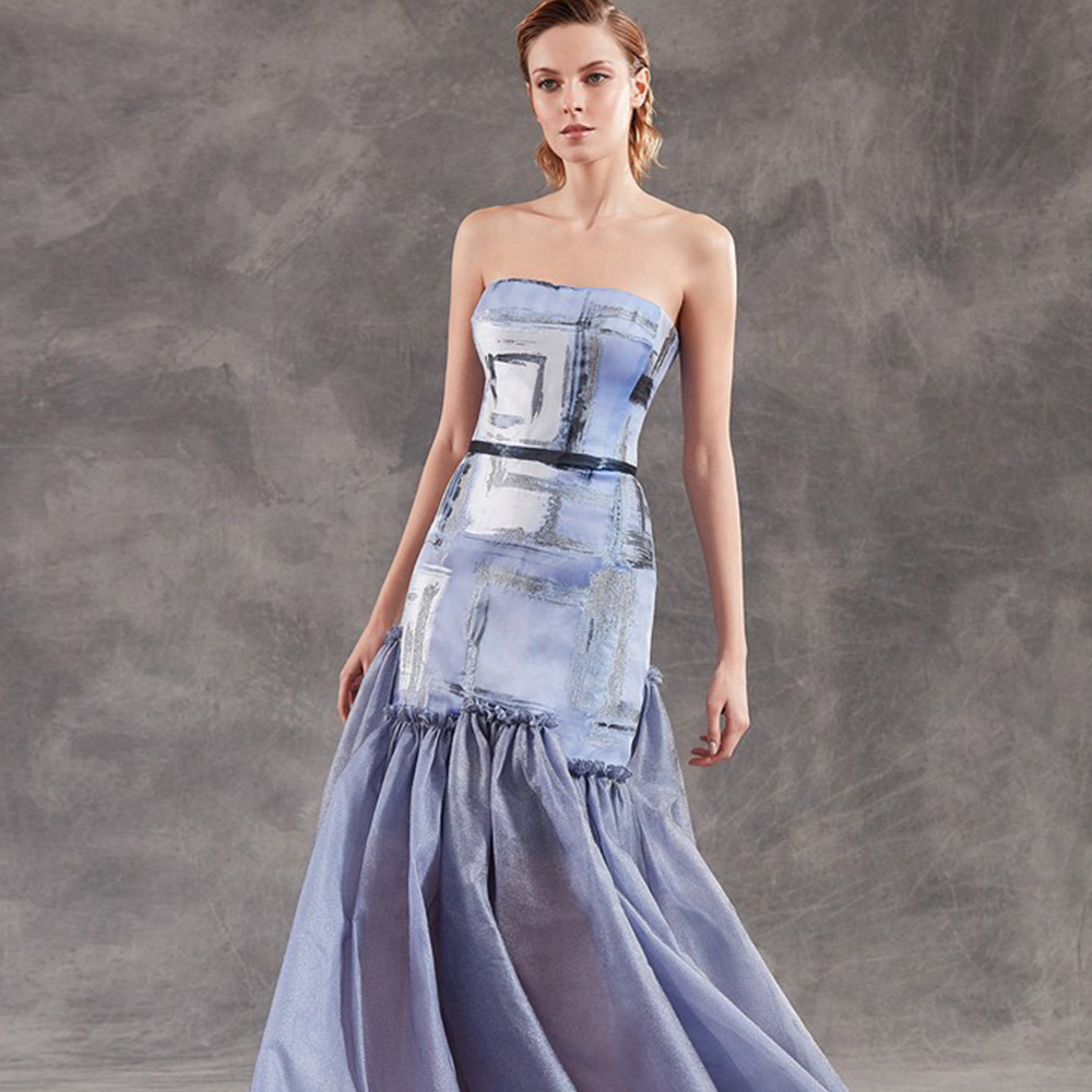 This strapless mermaid gown in organza with metallic tulle panels on the skirt.