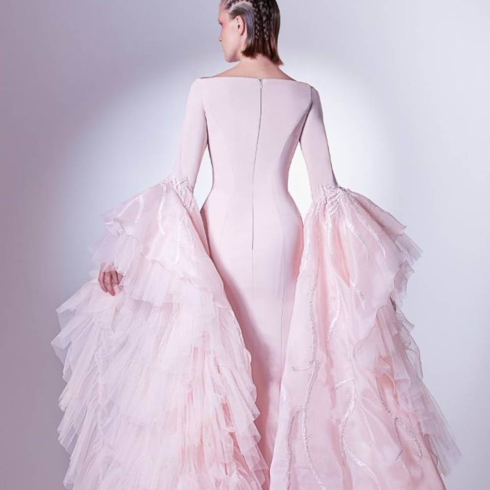 A timeless classic in elegance, this dress is designed in pale pink. The sleeves feature an endless flock of tulle.