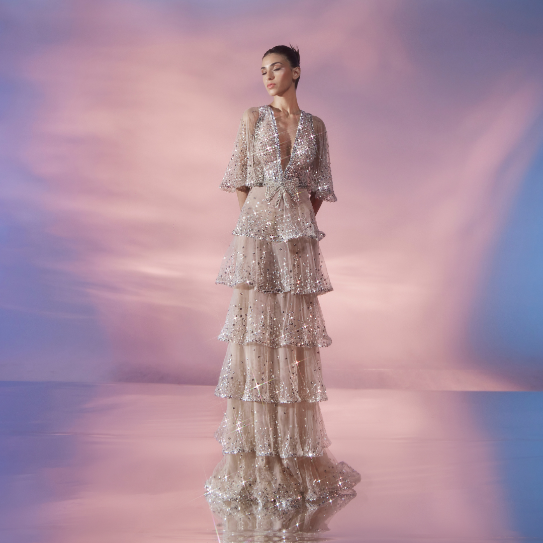 Plunging neckline flutter sleeve Nude tulle dress, layered skirt adorned with shimmering Silver embellishments.