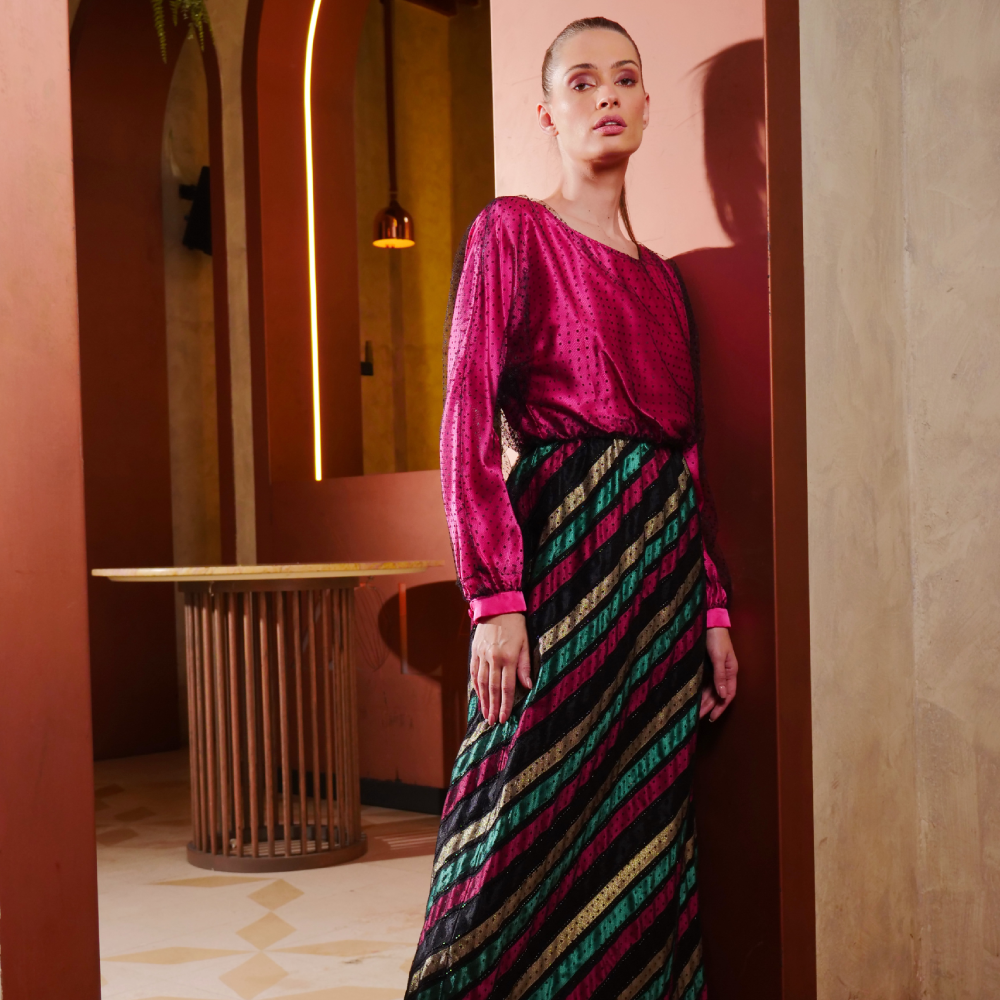 Fuchsia satin long dress paired with a striped skirt, wrapped elegantly in black dotted tulle.