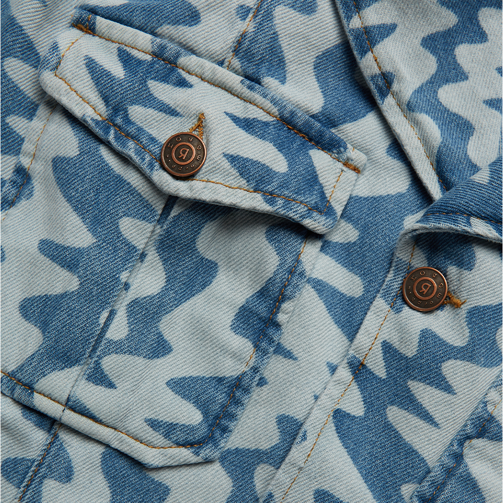 Horde Studio white denim jacket is patterned with cerulean blue wavy motif. It’s crafted from a rigid denim 