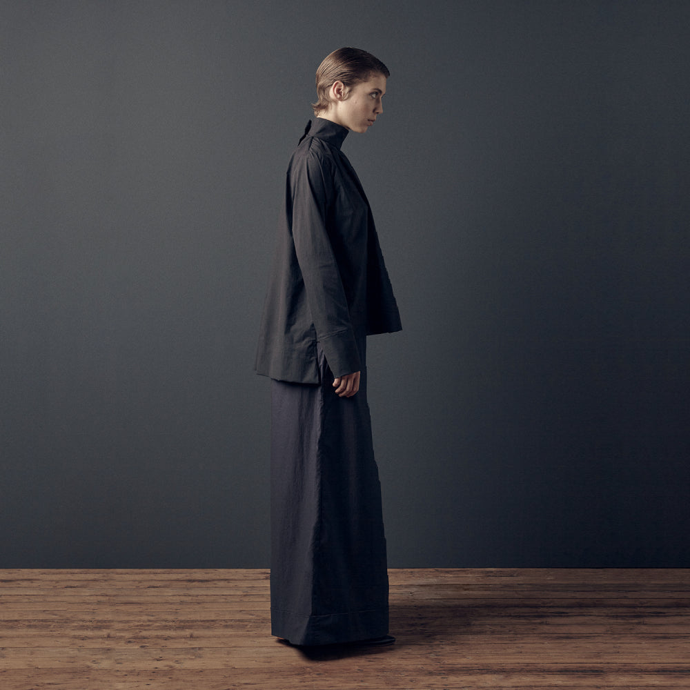 Discover the Ila Blouse at The Luxe Maison, featuring a wide-cut silhouette, stand-up collar, concealed back fastenings, and an asymmetric waistband for versatile styling.