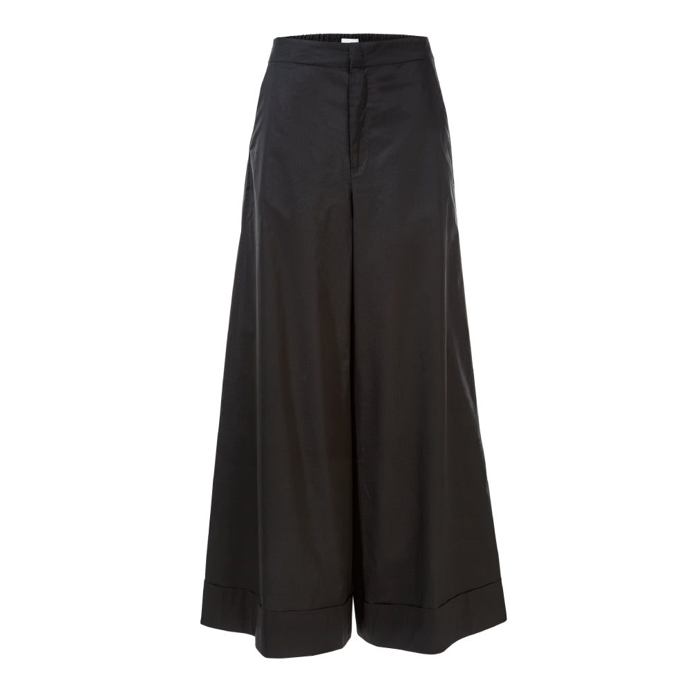 Discover the Ila Trousers at The Luxe Maison, featuring a high-waisted palazzo fit, flared legs, wide turn-ups, an elasticated back waistband, and practical pockets.