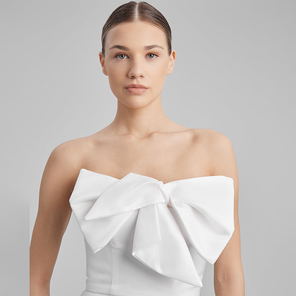 Step into contemporary elegance with our white mini dress with strapless corset and a removable bow. Explore our range of mini dresses. Shop now!