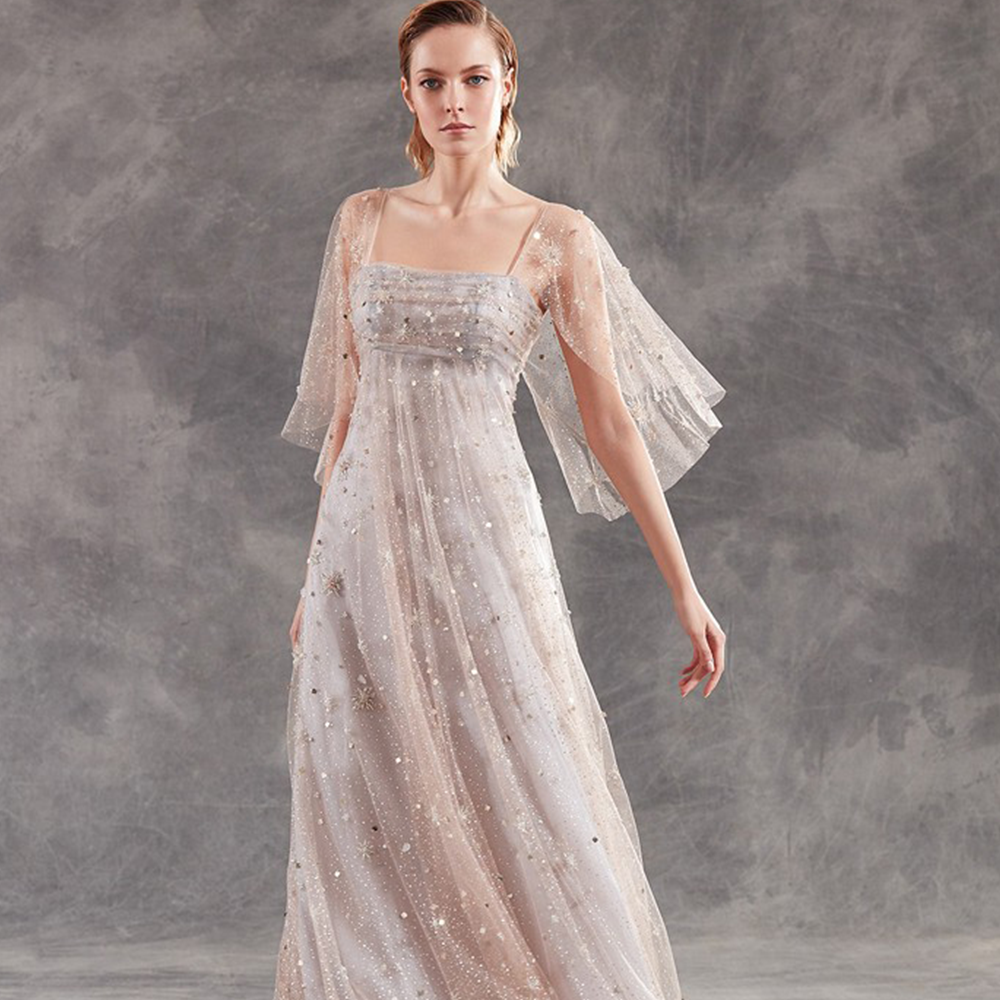 Sheath gown in hand embroidered laminated polka dots tulle with wide sleeves.