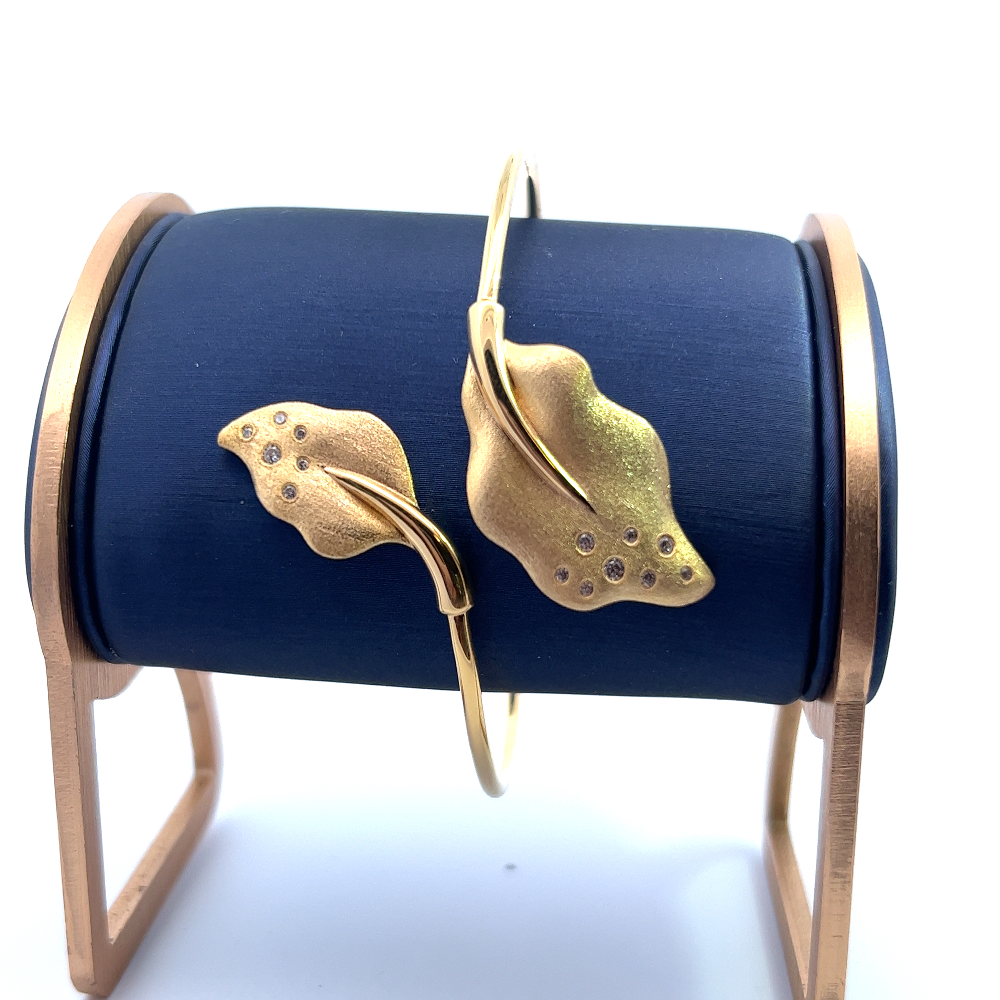 Handcrafted 18k gold-dipped sterling silver open bangle with cubic zirconia leaf accents on each side for a delicate modern statement. Shop premium jewelry online.