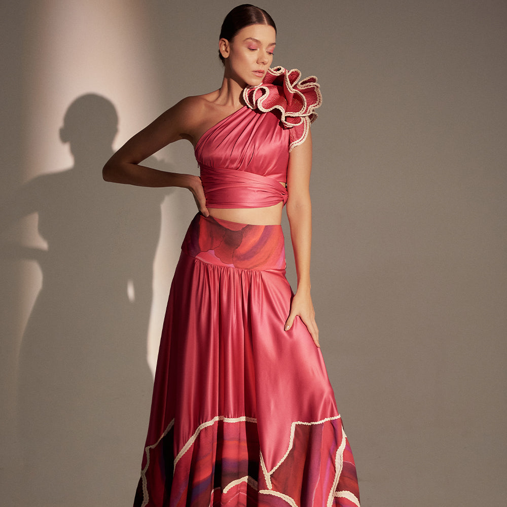 Draped one-shoulder crop top, adorned with ruffle appliqué, golden stitching, and wrap-around tie.