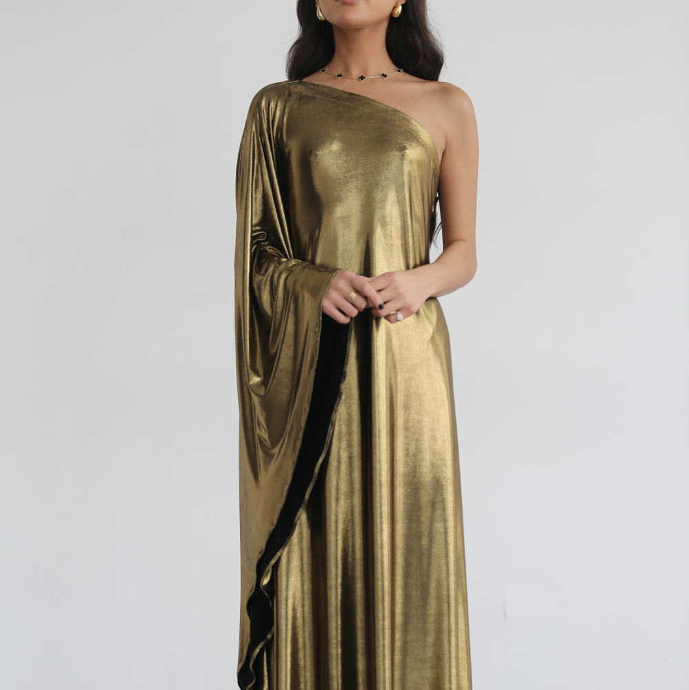 A metallic gold maxi gown with one-shoulder single draped extra-long sleeve with straight hem.