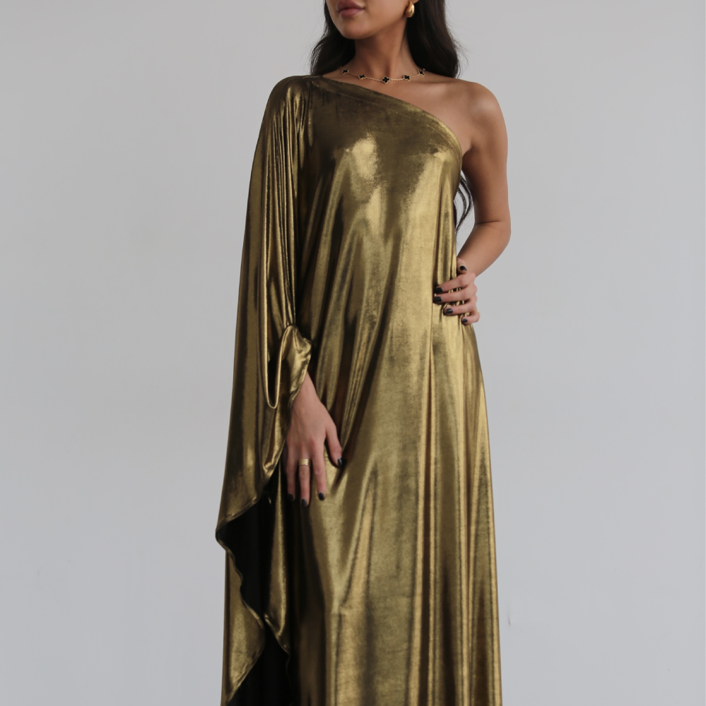 A metallic gold maxi gown with one-shoulder single draped extra-long sleeve with straight hem.