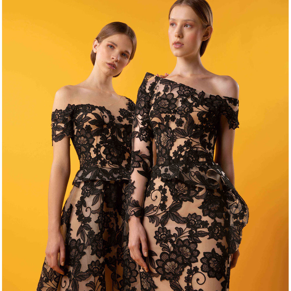 Asymmetrical off shoulder dress with floral laced fitted gown, side hip ruffle and unbalanced sleeves.