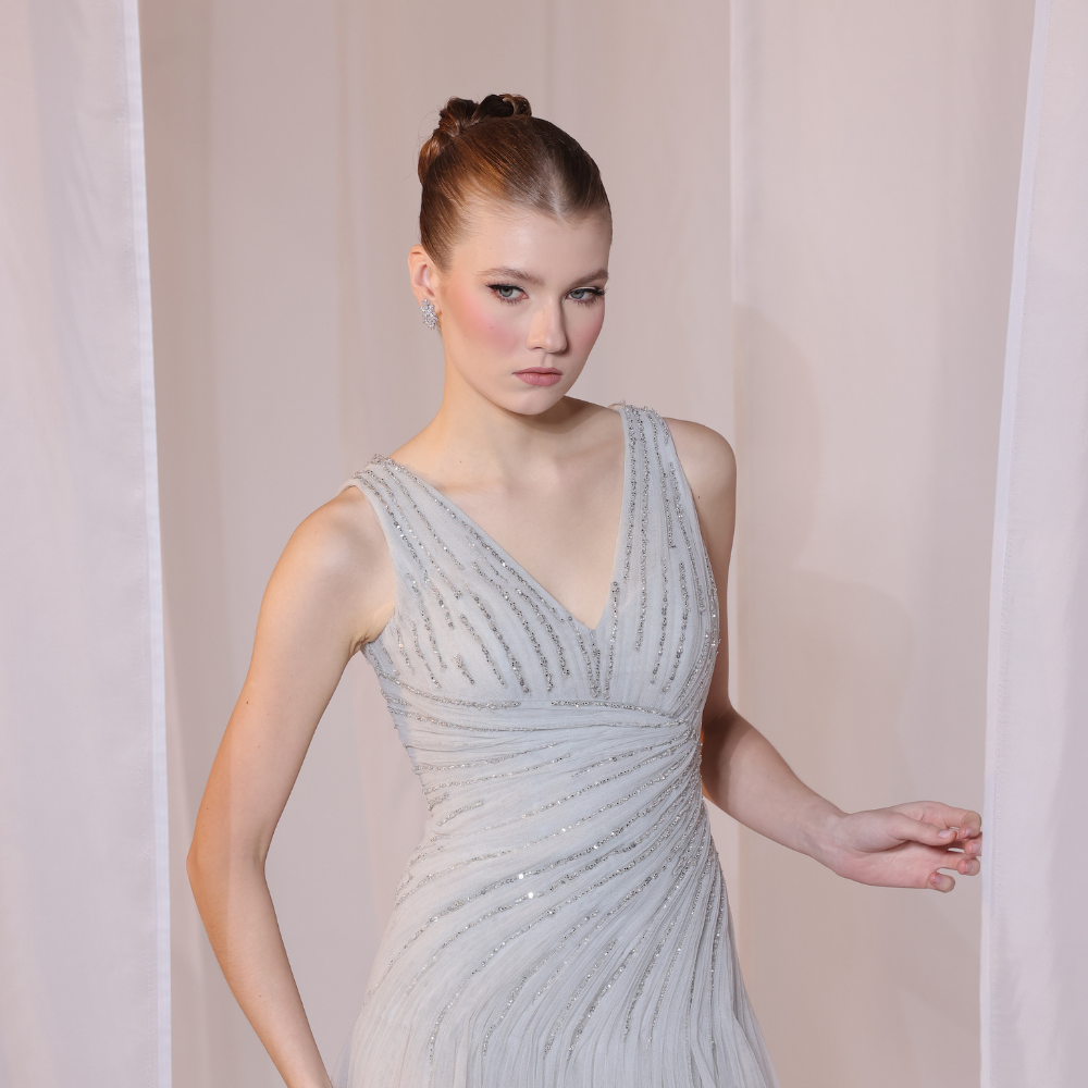 Shop online soft grey gown with delicate V-neckline, subtle shimmer and airy flowing silhouette, perfect for parties and special occasions.