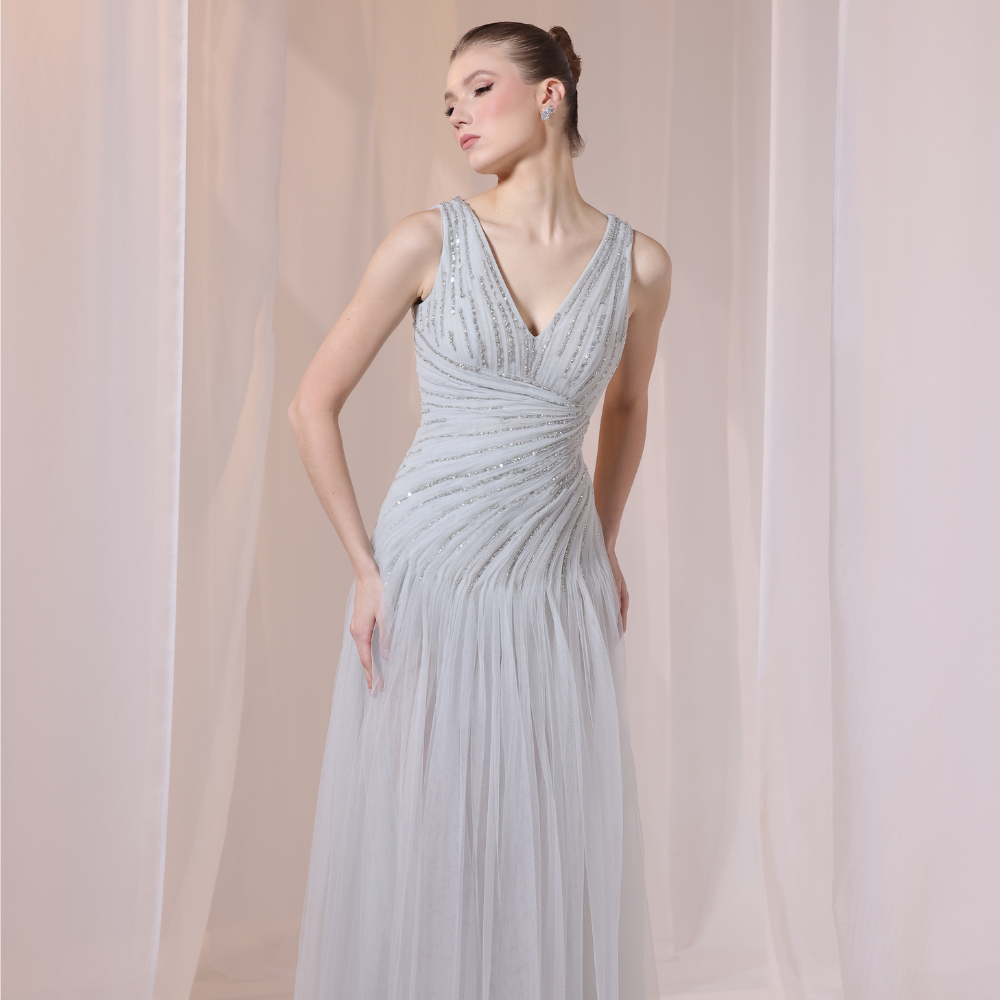 Shop online soft grey gown with delicate V-neckline, subtle shimmer and airy flowing silhouette, perfect for parties and special occasions.