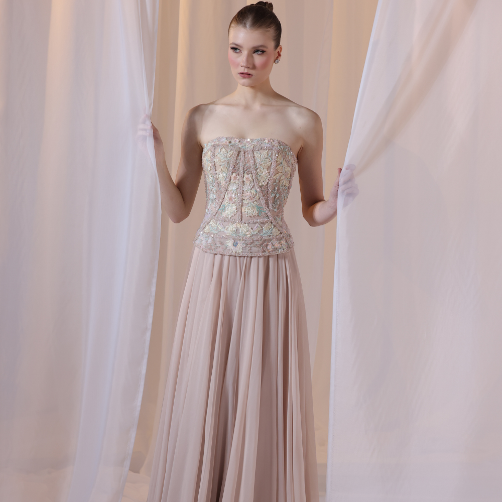 Shop online soft nude gown with embellished corset bodice and flowing pleated silhouette, perfect for parties, receptions and special occasions.