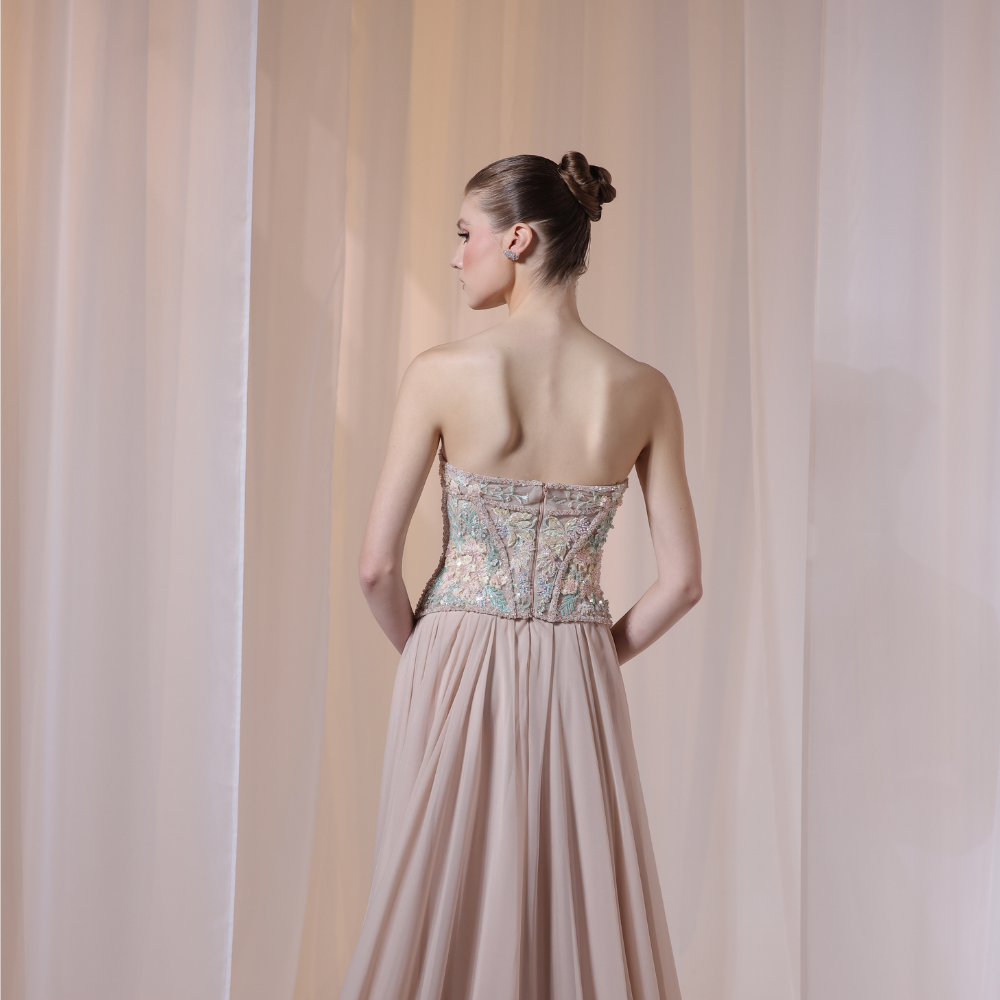 Shop online soft nude gown with embellished corset bodice and flowing pleated silhouette, perfect for parties, receptions and special occasions.