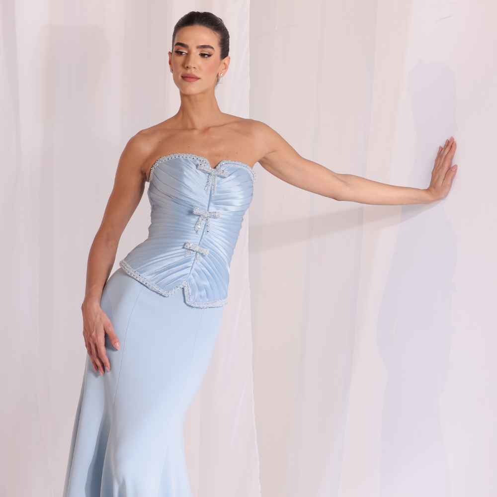 Shop online light blue gown with structured corset bodice, soft pleated details and sleek elegant silhouette, perfect for parties and special occasions.