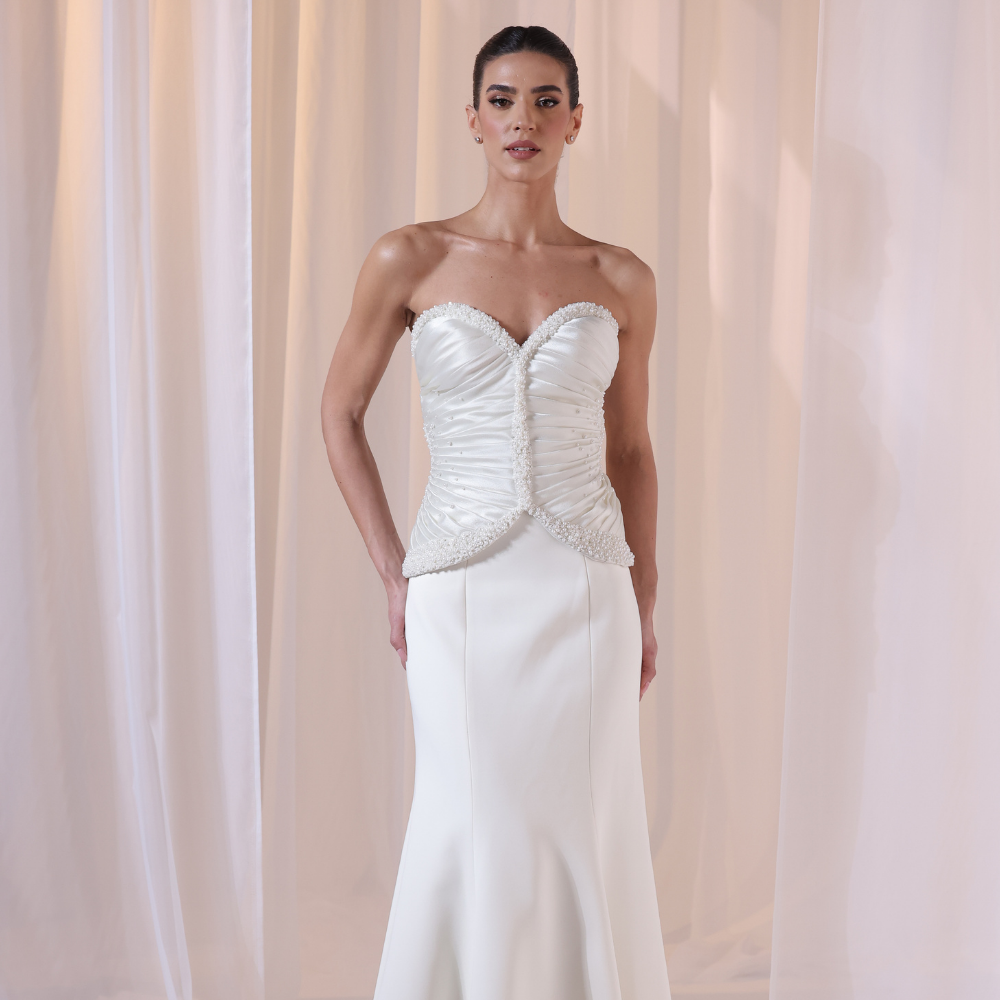 Shop online timeless ivory gown with structured corset, delicate ruching and flowing silhouette, perfect for weddings, receptions and special occasions.