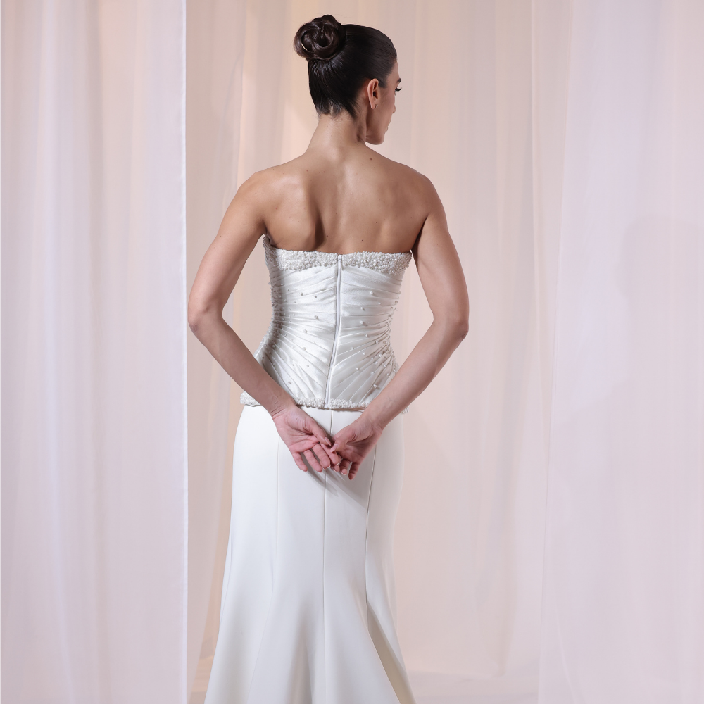 Shop online timeless ivory gown with structured corset, delicate ruching and flowing silhouette, perfect for weddings, receptions and special occasions.
