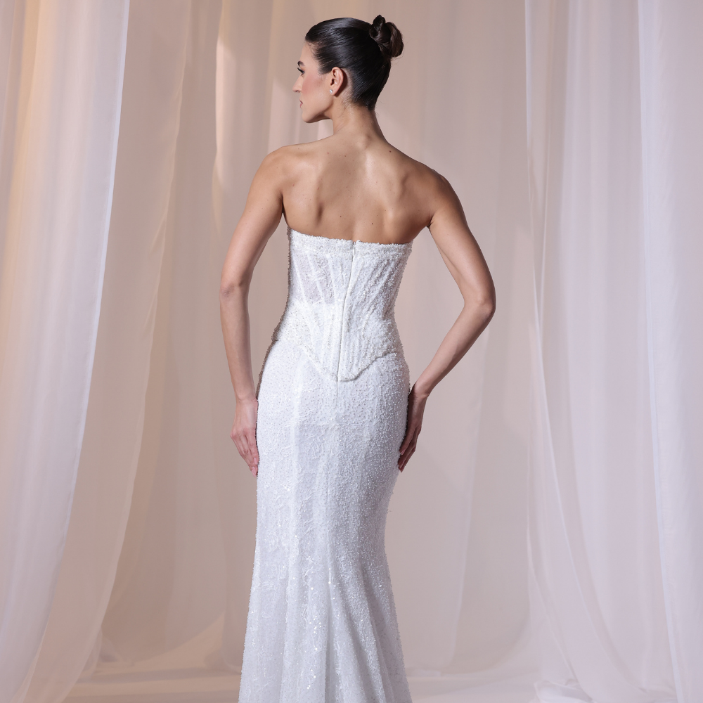 Shop online soft ivory gown with delicate shimmer, structured corset bodice and elegant fitted silhouette, perfect for parties and special occasions.