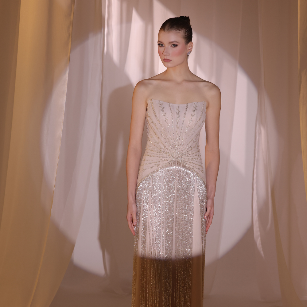 Shop online blush embellished gown with delicate detailing and fluid shimmering layers, inspired by Charleston elegance and perfect for special occasions.