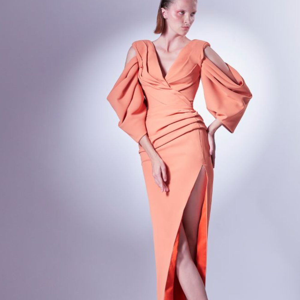 The V-neck and open shoulders give it a sense of modernity, while the draping is wrapped and gathered around the waistline.