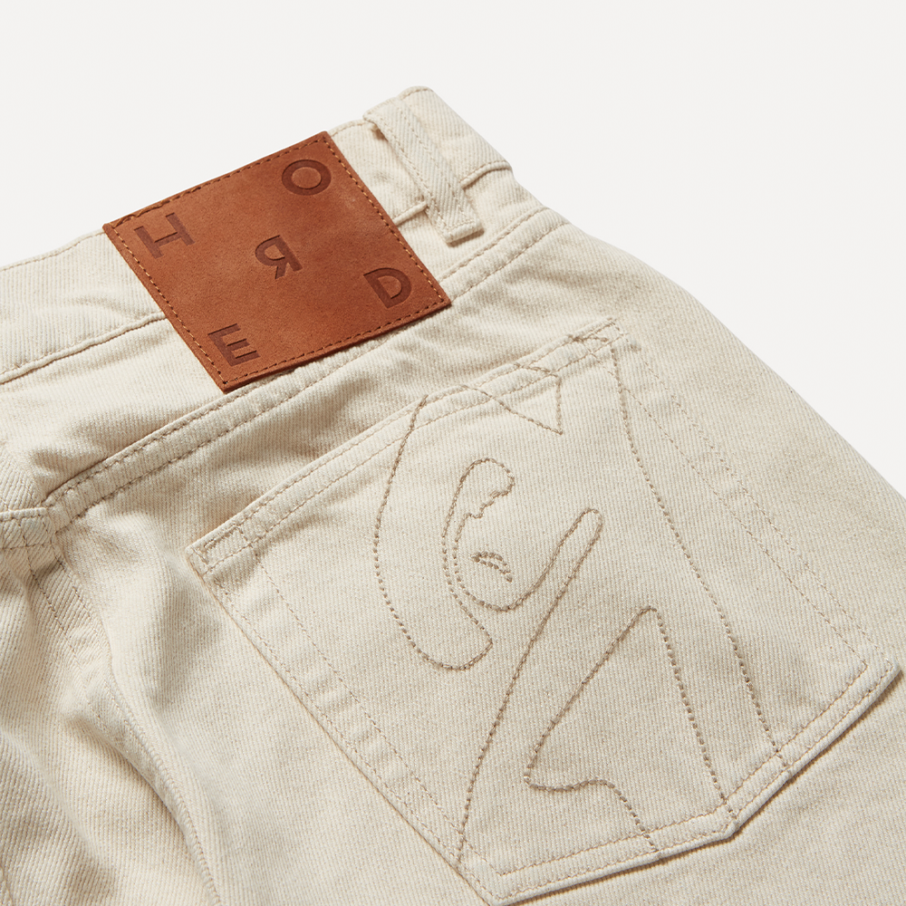 Cut for a slim fit with a flared hem in natural off-white organic 100% cotton mid-weight denim.
