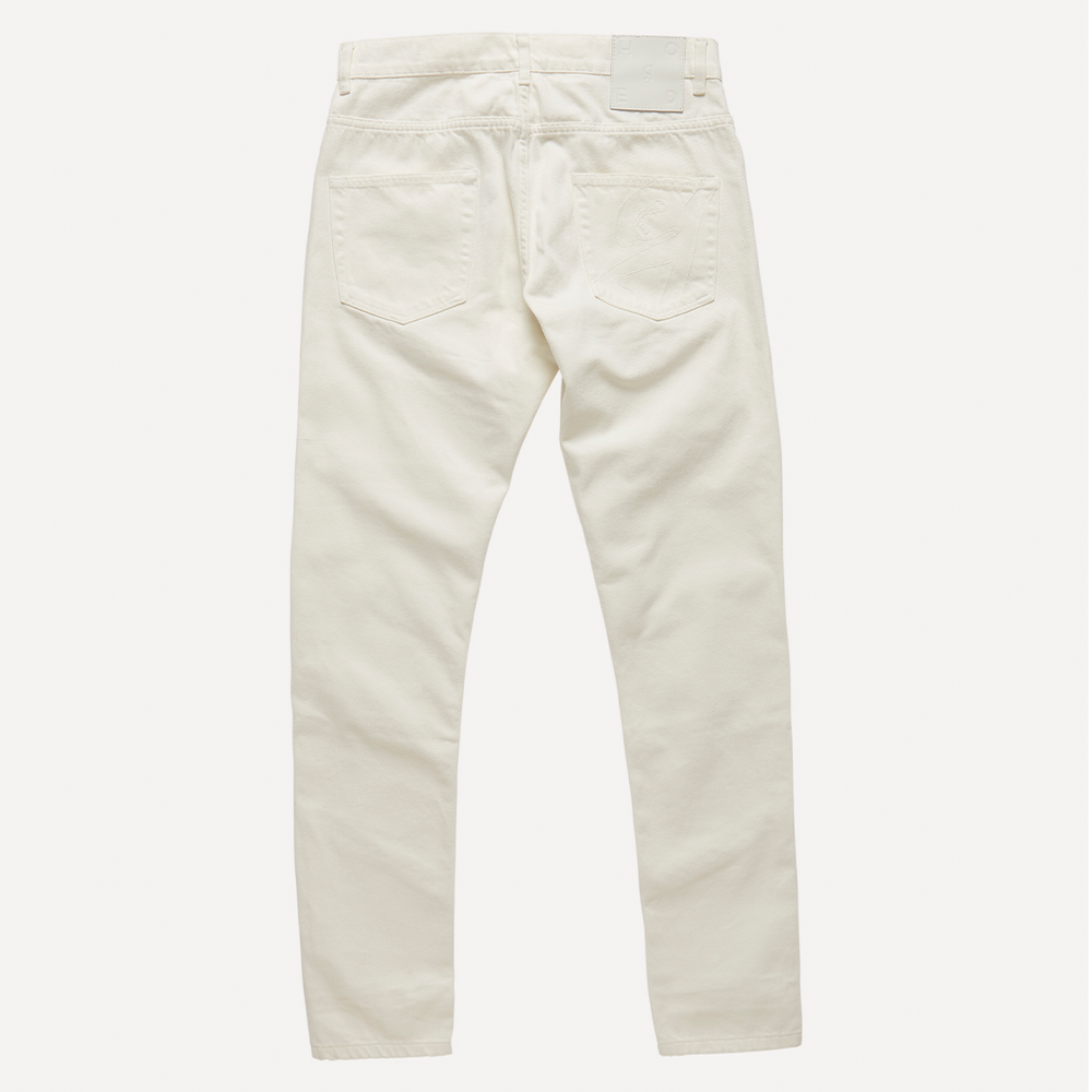 Natural off-white mid-weight 100% cotton organic denim with linear cut-outs. Cut for a mid-rise, straight-leg fit with cropped length.