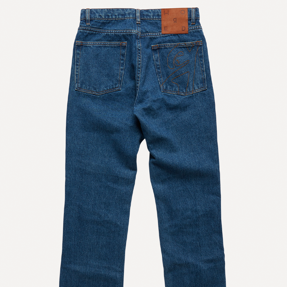 Dark blue mid-weight 100% cotton organic denim with linear cut-outs. Cut for a mid-rise, straight-leg fit with cropped length