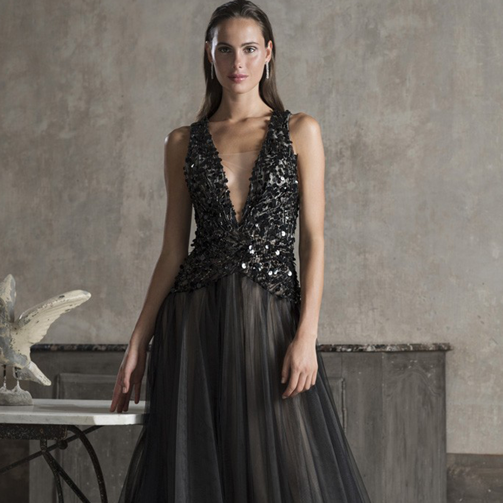 Sheath gown in illusion tulle and silk georgette with deep neckine and bodice hand beaded with sequins.
