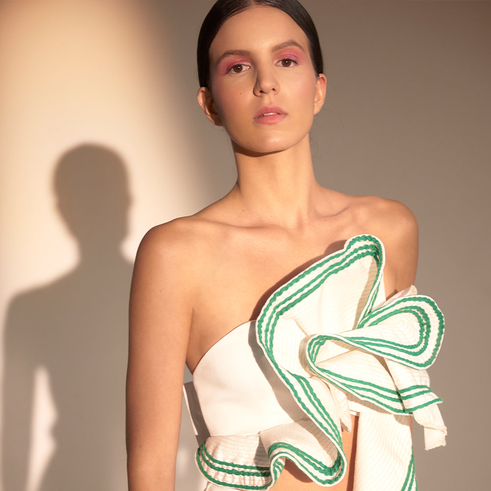 Strapless crop top with wrap-around ruffle, contrasting embriodery, vertical cascade, and back tie.